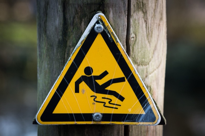Yellow sign showing a man slipping and falling